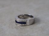 a close up of a ring with blue stones on it
