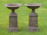 two stone urns sitting on the grass in the yard