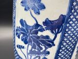 a blue and white vase with a rope wrapped around it