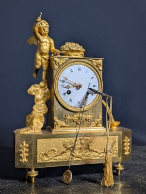 une horloge en or surmontée d'une statue