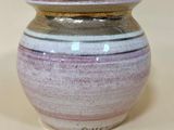 a purple and white vase sitting on a white surface