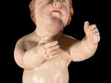 a small statue of a child with his hands in the air