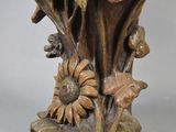 a bronze vase with flowers and leaves on it