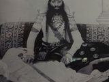 a black and white photo of a man with a beard sitting on a couch