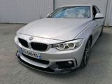 La BMW argentée est garée devant un immeuble.