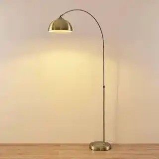 Le lampadaire est posé sur le parquet de la pièce.