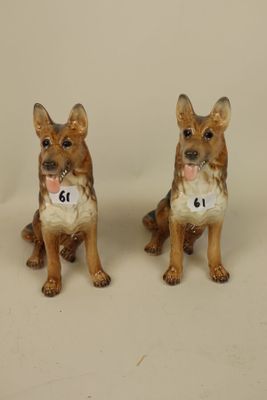 two figurines of dogs sitting next to each other