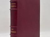 a red book sitting on top of a table next to a white wall