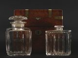 pair of antique glass decanters with wooden box on black background