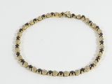 un bracelet composé de perles dorées et noires sur fond blanc