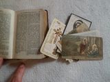 a person holding a book with pictures of jesus on it