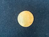 a close up of a gold coin on a blue cloth