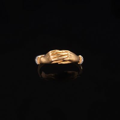 une image représentant une bague en or sur laquelle sont posées deux mains