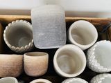 many bowls and cups sitting in a box on the floor