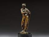 une statue en bronze représentant une femme tenant un enfant dans ses bras, posée sur un socle