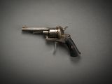 an old revolver with a black handle on a gray surface