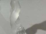 a glass sculpture of a woman on a table