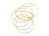 un gros plan sur une pile de bracelets en or sur fond blanc