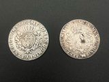 two silver coins, one with a crown and the other with a coat of arms