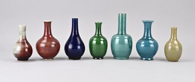 Plusieurs vases de différentes couleurs sont alignés en rang