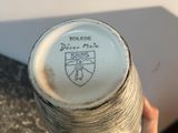 a person holding a vase that has a logo on it
