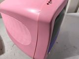 a pink television sitting on top of a white table