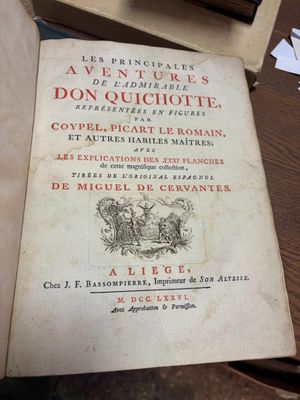 un vieux livre posé sur une table en bois, à côté d'une pile de papiers