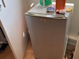 a small refrigerator in the corner of a room