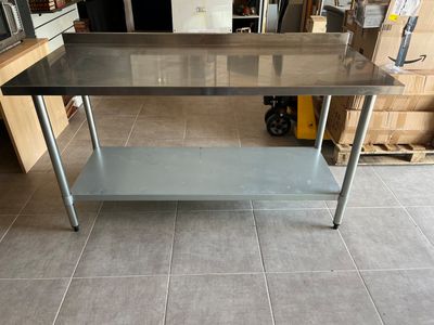 une table en acier inoxydable au milieu d'une pièce