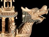 a statue of a dragon with a tower in the background