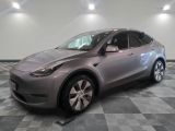 La Tesla Model Y est garée sur un sol en carrelage à damier.