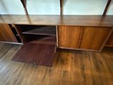 a wooden desk with shelves and a door open