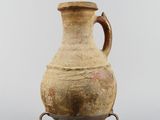 an old vase with a handle on a stand on a white background