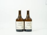 deux bouteilles de vin posées l'une à côté de l'autre sur une surface blanche