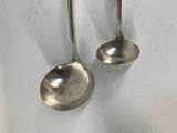 pair of silver spoons hanging from a hook on a wall