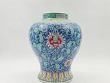 un vase bleu et blanc orné d'une fleur rouge