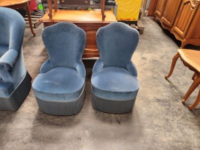 deux chaises bleues et une table dans une pièce où il y a beaucoup de meubles