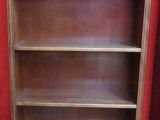 une bibliothèque en bois avec deux tiroirs et une porte