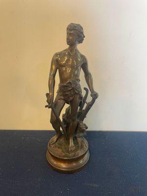 bronze statue of a man with a dog on a blue table