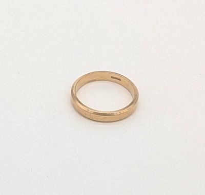 une image représentant une alliance en or posée sur une surface blanche