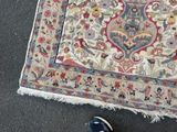 a person standing next to a rug on the ground