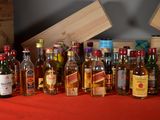 many bottles of alcohol sitting next to each other on a table