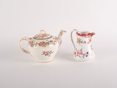 pair of small porcelain teapots with floral designs on them