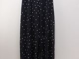 a black and white polka dot print pants hanging on a wall