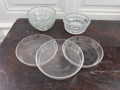 four clear glass bowls sitting on a table next to each other