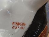 a close up of a vase with a bird on it