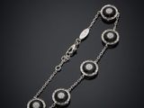 un bracelet en argent orné de pierres noires et blanches sur fond noir
