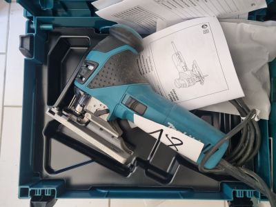 a blue box with a tool in it on a tiled floor