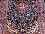 a black rug with a red and blue design on it