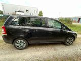 a picture of a small black car parked on a dirt road